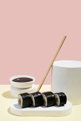 Asian culture, Japanese hosomaki (sushi, rolls) with eel on a pink and yellow background. Oriental culinary, eastern cooking.