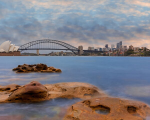 Sydney Harbour Australia at Sunset with the turquoise colours of the bay and high rise offices of the City in the background
