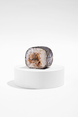 Japanese hosomaki (sushi, rolls) with eel on a white plaster stand on a white plain background.