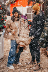 Photo of stylish family mommy daddy daughter piggyback happy positive smile look each other winter holliday outdoors
