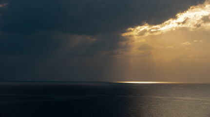 Sunrise in the sea with cloud stormy clouds and orange colour. Seascape in the morning. Sun rays in...