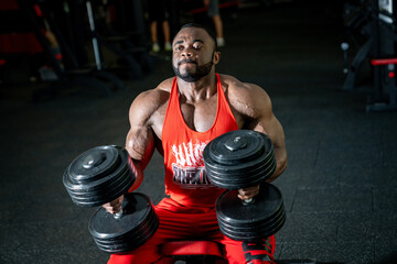 Fototapeta na wymiar Athlete powerful young bodybuilder. Strong muscular man in gym training.