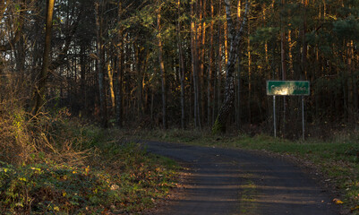 Znak drogowy tablica z nazwą miejscowości Czarna Glina . Droga w środku lasu .