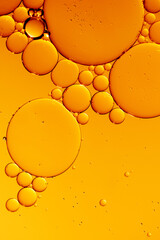 Golden yellow abstract oil bubbles or face serum background. Oil and water bubbles macro photography. - 550701513