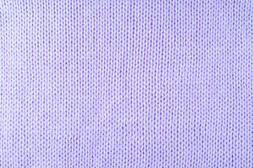 Close up background of knitted wool fabric made of viscose yarn. Pastel purple color wool knitwear...