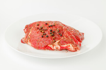 Fresh piece of pork meat on a white plate, close-up.