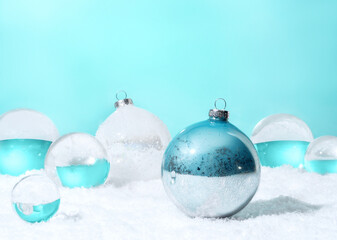 Transparent glass orbs and Christmas balls with white snow on cyan background. Christmas...