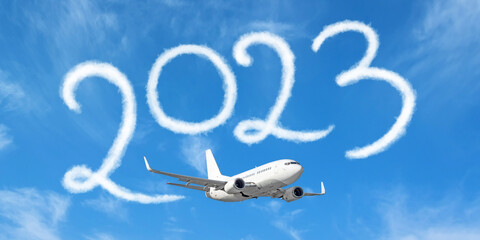 Happy New year 2023 on the background below cloudscape. Drawing by passenger airplane vapor...