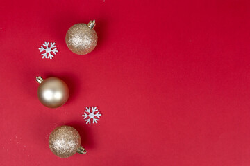 Red christmas background with golden balls and silver snowflakes top view with copy space.