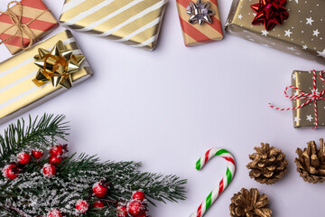 Christmas background frame with copy space on white, decoration elements with striped gift boxes candy canes, green fir tree branch and pine cones
