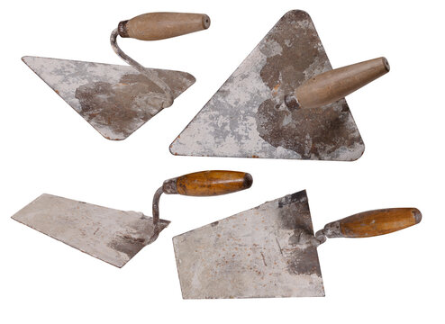 Two dirty masonry trowels on an isolated background.