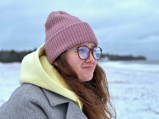 Portrait of sad upset frustrated young woman is suffering, freezing at winter cold day. Frozen girl walking