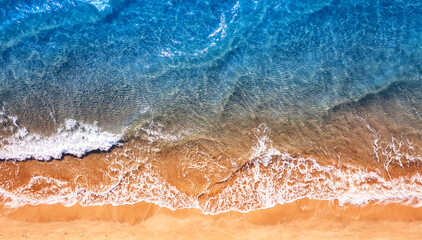 Turquoise water wave with sand beach background from aerial top view. Concept summer sunny travel...