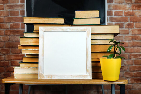 Books and a flower on the background of the school blackboard. Copy space. Lay out - Powered by Adobe