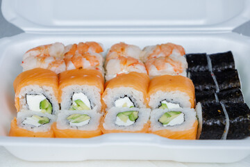 Large box of Philadelphia rolls. Fast delivery sushi in a white container