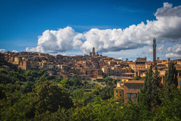 Fototapeta na wymiar Beautiful panoramic view of the historic city of Siena at daytime with an amazing cloudscape on an idyllic autumn evening, Tuscany, Italy. October 2022