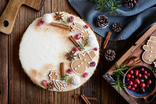 Eggnog gingerbread tart decorated with sugared cranberries, gingerbreads, cinnamon and star anise