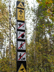 Informative sign appealing for not to pick the flowers, not to litter, do not bring dogs and not to make noise in the forest