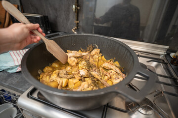 Rabbit meat cooking in a big pan on a kitchen indoor