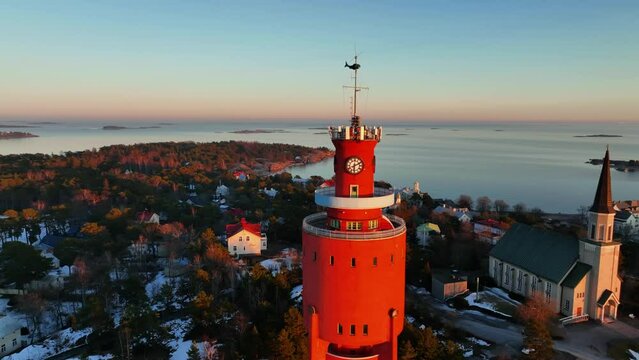 Aerial view around the sunlit watertower, sunny morning in Hanko city, Finland - orbit, drone shot