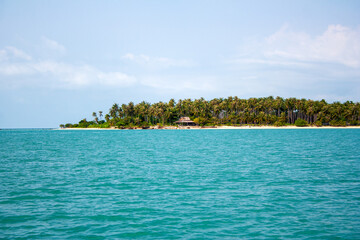 Tropical island with palm trees and sandy beach in turquoise color sea