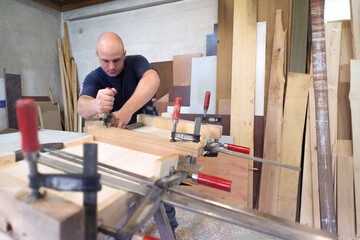 Young carpenter working on his project in his carpenter workshop