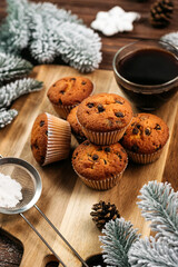 
muffins with chocolate on a wooden stand, powdered sugar, cones, Christmas tree branches nearby