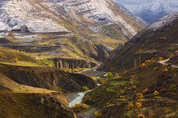 Fantastic high rocks. Autumn landscape with steep mountain and river. Caucasus Mountains in Dagestan, Russia. Panoramic view of the Caucasian ridges and sharp rocks