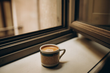 Coffee cup near the window with shutters in Turin, Italy.