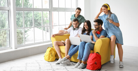 Students with modern devices studying online indoors