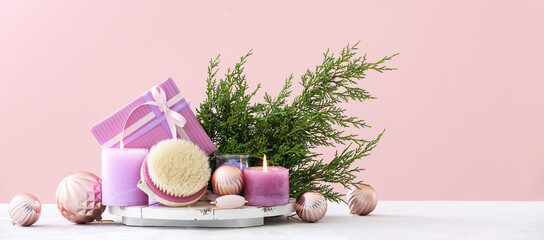 Christmas gift with spa set on table against pink background