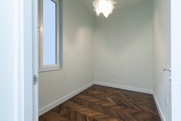 Interior of an empty apartment with brown wooden parquet