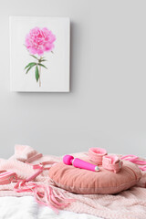 Pillow with pink sex toys on bed near grey wall