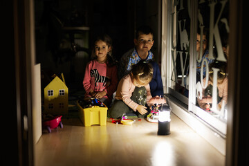 Kids playing at home during a blackout using lantern.