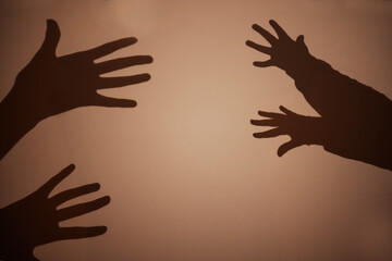 Shadow of the hand and fingers on the wall.