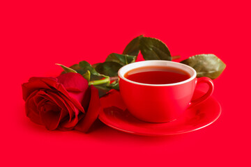 Cup of tea and red rose flower on color background