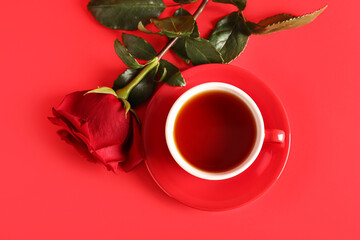 Cup of tea and red rose flower on color background