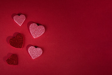 Valentine's day concept banner with sparkling glitter hearts against abstract red background and the bokeh of garland with space for text.