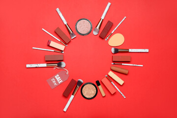 Frame made of cosmetic products and sale tag on red background