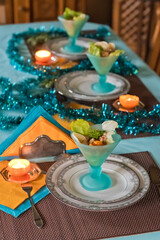 Fototapeta na wymiar Festively served table, anticipation of Christmas, sea salad in turquoise bowls