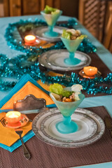 Festively served table, anticipation of Christmas, sea salad in turquoise bowls