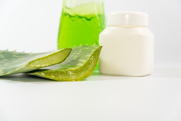 Obraz na płótnie Canvas Aloe Vera leaves, plastic container and detergent bottle on a table