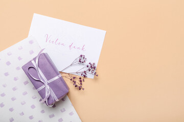 Composition with card, gift box and notebook on color background