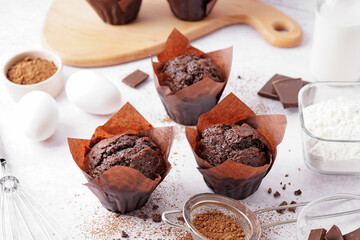 Delicious chocolate muffins on table
