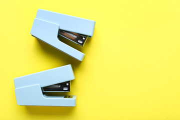 Office staplers on yellow background