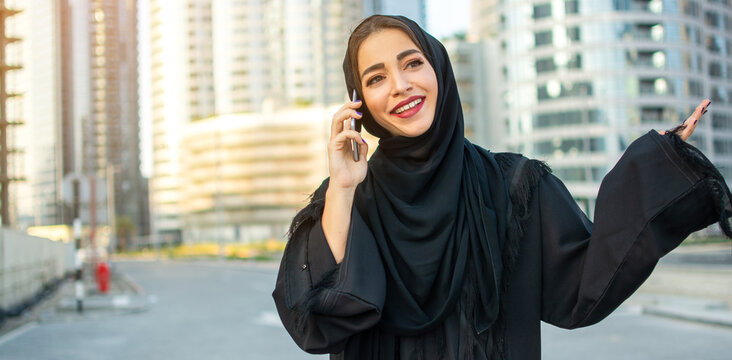 Beautiful Arabic Woman Talking On Phone On The Street Wearing Traditional Arabic Clothing.