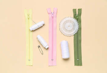 Set of sewing supplies with thread spools on color background