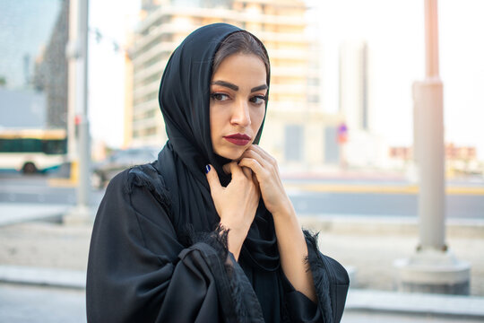 Beautiful scared arab young woman wearing traditional arabic clothing on the street.
