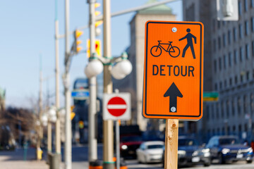 Orange detour sign for bikes and pedestrians. Closed road in Ottawa, Canada.
