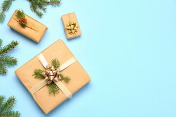 Fototapeta na wymiar Christmas gift boxes with fir branches on blue background